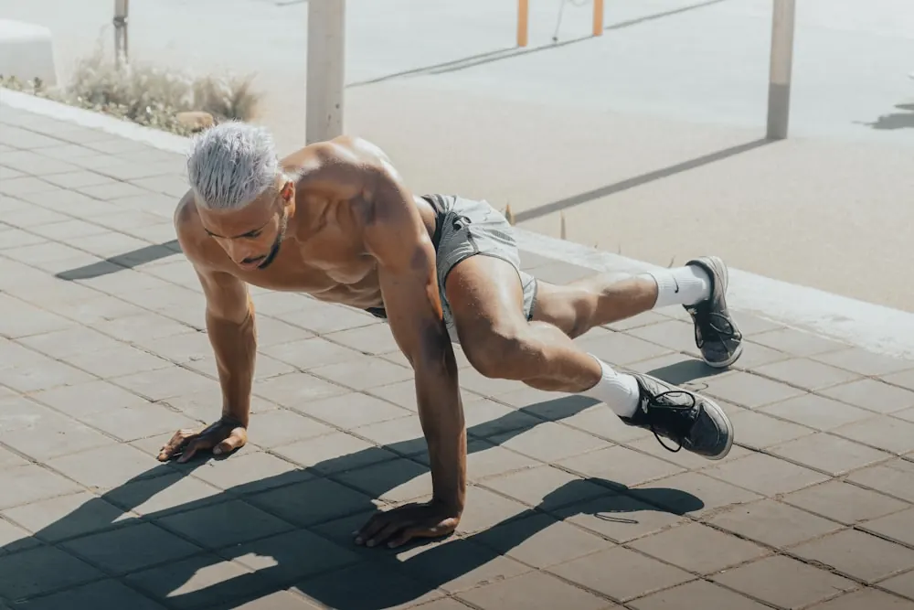 Hombre practicando un apoyo de fuerza en una superficie exterior