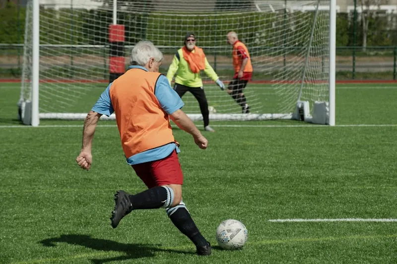 Grupo de personas adultas jugando con un balón en un espacio abierto